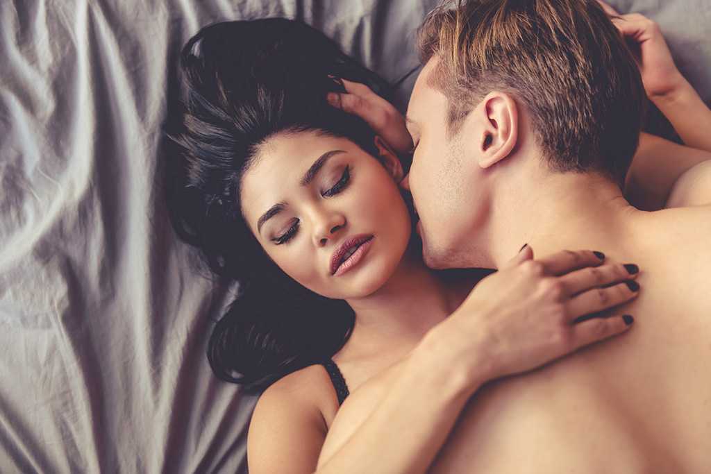 Мужчина страстно ласкает. Близость между мужчиной и женщиной. Поцелуи в кровати.